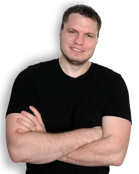 Man in black t-shirt standing with crossed arms and smiling